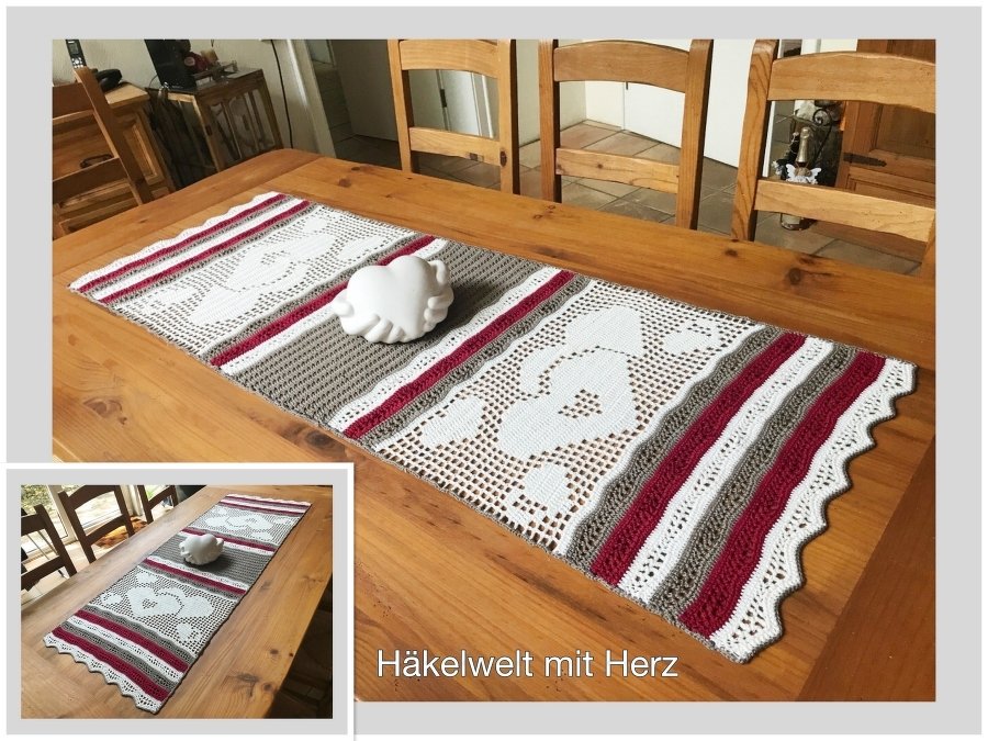 Gehäkelter Tischläufer mit Herzmotiven, roten Streifen auf Holztisch