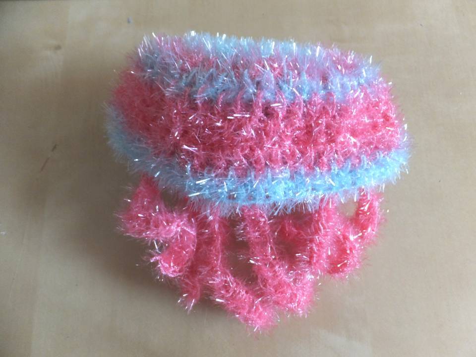 Handgehäkelter flauschiger Badeschwamm in Rosa und Hellblau mit fransiger Textur