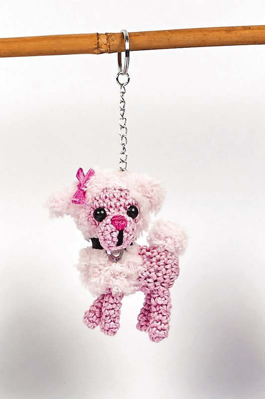 Rosa gehäkelter Pudel-Amigurumi Schlüsselanhänger mit Schleife an Metallkette