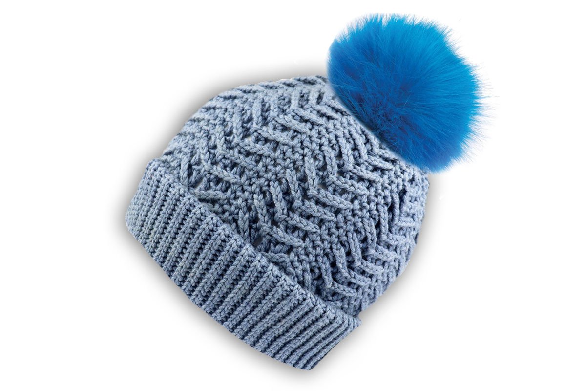 Light blue crocheted beanie with ribbed cuff and bright blue fluffy pompom on white background