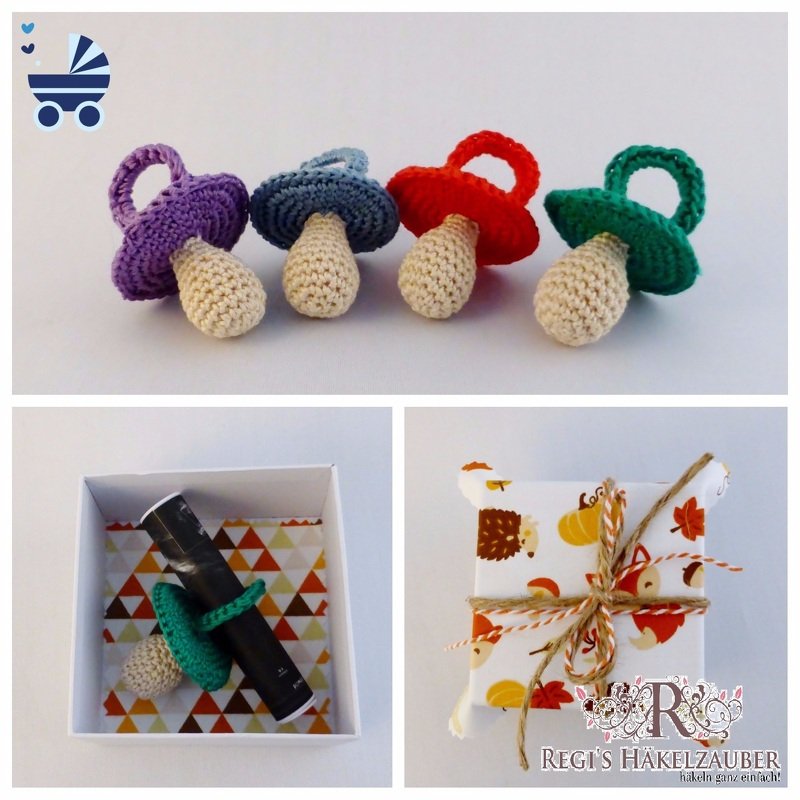 Vier gehäkelte Babyschnuller (lila, blau, rot, grün), einer in einer Geschenkbox mit gemustertem Papier