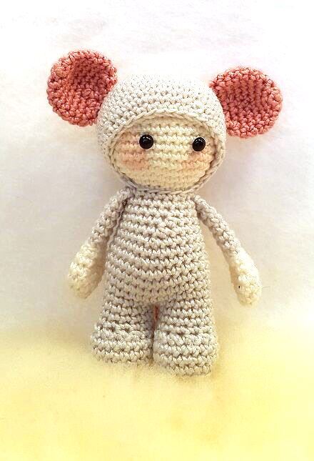 helle gehäkelte Amigurumi-Puppe mit rosa Ohren und schwarzen Augen
