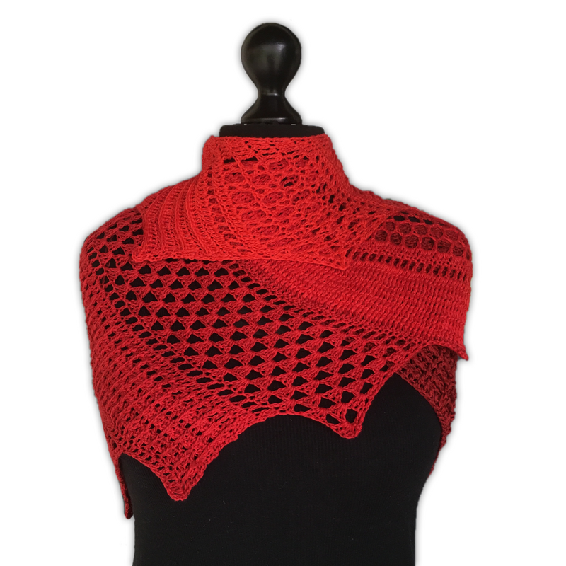 Red crochet dragon tail scarf with lace mesh and scalloped points draped on a black mannequin