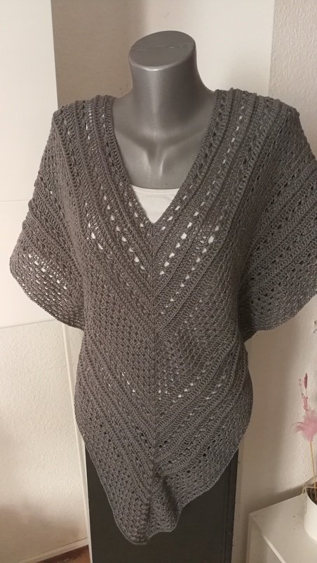 Grau gehäkelter Poncho mit V-Ausschnitt auf Mannequin