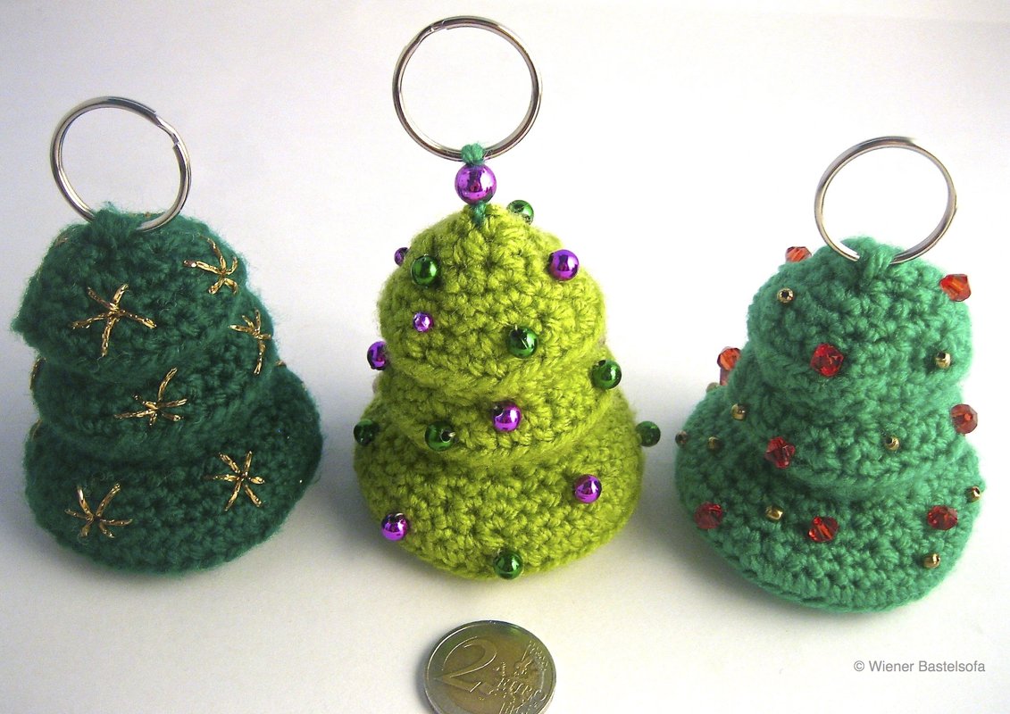 Drei gehäkelte Weihnachtsbaum-Schlüsselanhänger in Grüntönen mit Perlen und goldener Stickerei