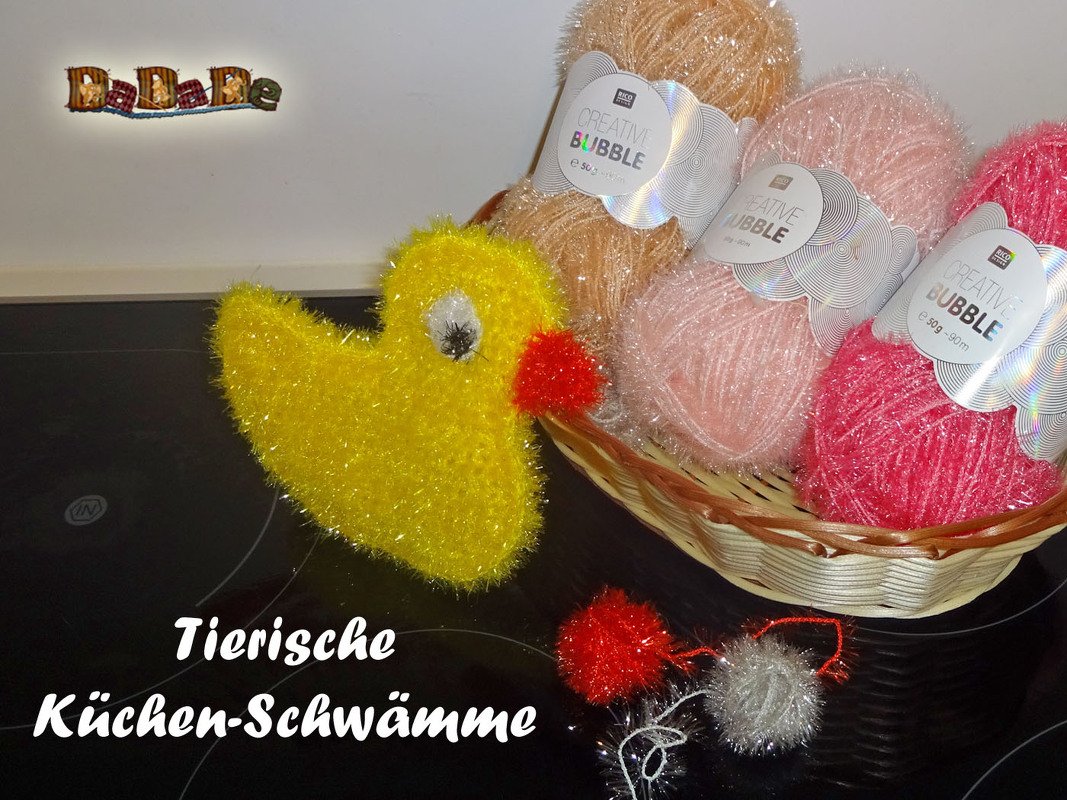Gehäkelter gelber Küchenschwamm in Entenform neben Korb mit flauschigen Garnknäueln
