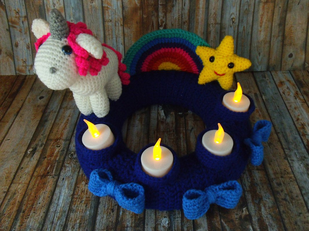 Dunkelblauer, gehäkelter Adventskranz mit Einhorn, Regenbogen, Stern und vier LED-Teelichtern