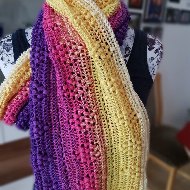 Gehäkelter Loop‑Schal in Violett, Pink und Gelb, an einer Schneiderpuppe drapiert