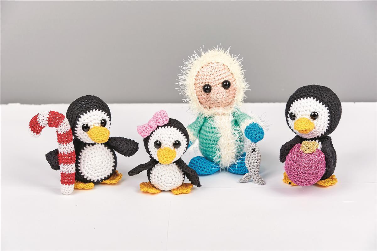 Vier gehäkelte Amigurumi-Figuren: drei Pinguine mit Accessoires und eine Puppe mit flauschiger Kapuze