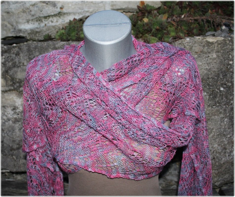 Gestrickter Ajour‑Schal in Rosa und Grau, über Kreuz drapiert