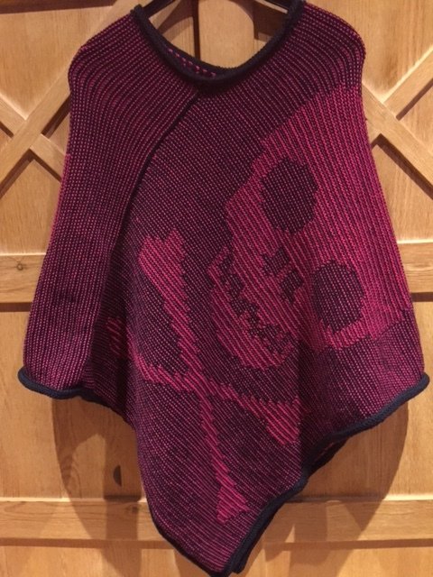 Zweifarbiger gestrickter Damenponcho in Magenta mit dunklem Totenkopf-Motiv und kontrastfarbener Kante