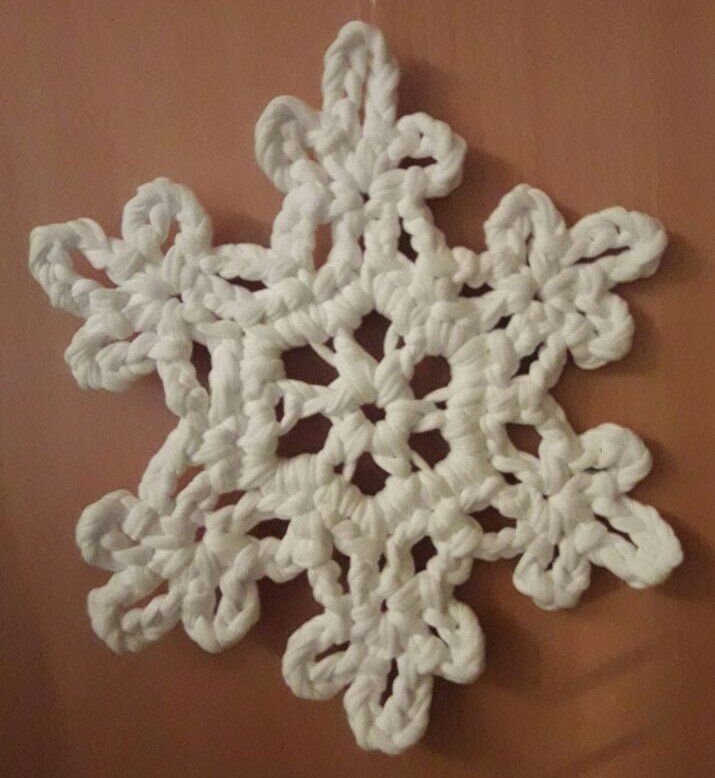 Große gehäkelte Schneeflocke mit strukturierten Maschen