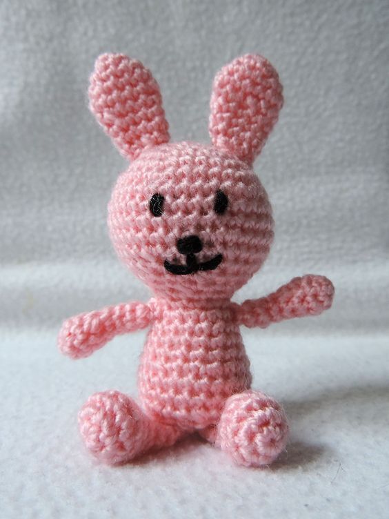 rosa gehäkelter Amigurumi-Hase mit gesticktem Gesicht und aufgerichteten Ohren