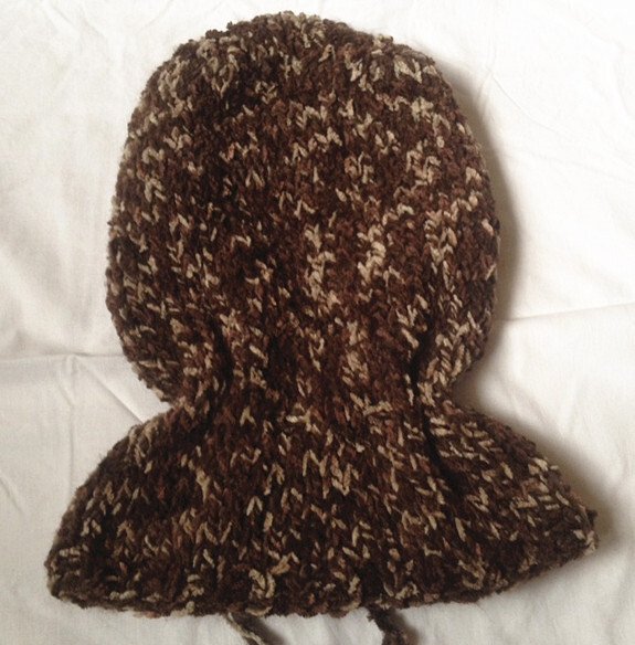 Braun-beige gestrickte Sturmhaube mit Nackenschutz auf weißem Untergrund