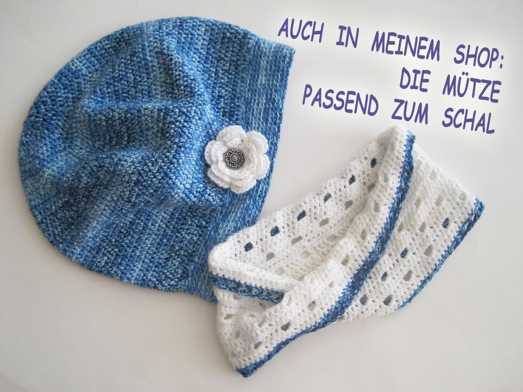 Weißer gehäkelter Loop-Schal mit blauem Rand und blau-melierte Mütze mit weißer Blüte
