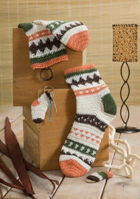 Gehäkeltes Set: Socken, Beinstulpen und kleiner Socken-Schlüsselanhänger in Creme, Braun, Grün und Terrakotta mit Mustermix.