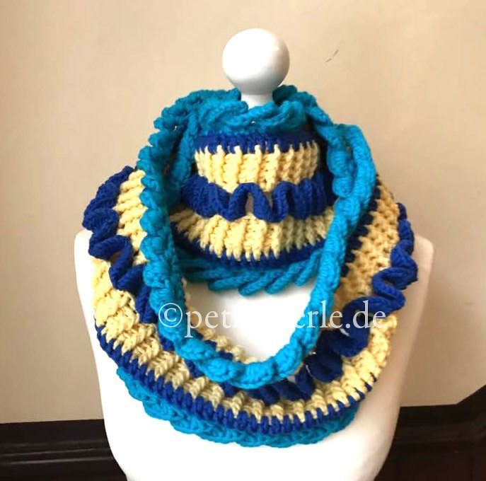 Gehäkelter Loopschal blau-türkis-gelb mit Wellenmuster an Schaufensterpuppe
