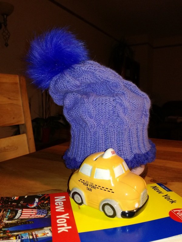 Lila Strickmütze mit Zopfmuster, Rippbündchen und blauem Bommel