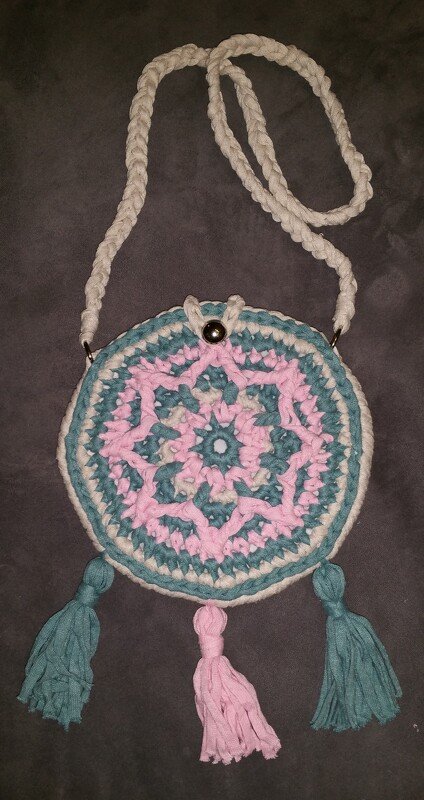 Runde gehäkelte Umhängetasche in Pastellfarben mit drei Quasten und geflochtenem Riemen