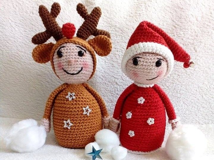 Zwei gehäkelte Amigurumi-Puppen: links braunes Rentier mit Geweih, rechts rote Wichtelpuppe mit Zipfelmütze, davor Wattebällchen und kleine Deko