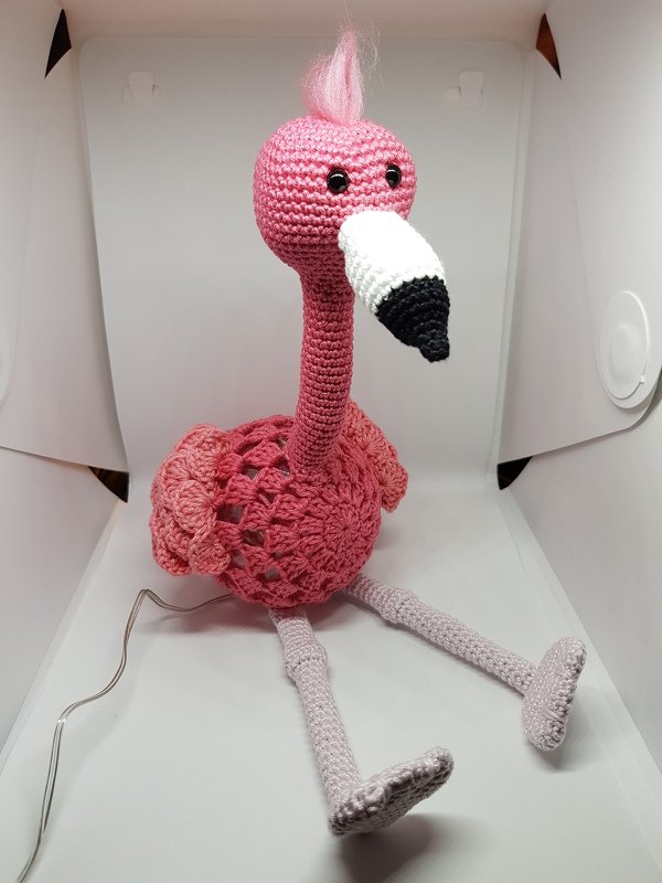 Gehäkelter Flamingo in Pink mit langem Hals, schlanken Beinen und kontrastierendem Schnabel auf hellem Hintergrund.