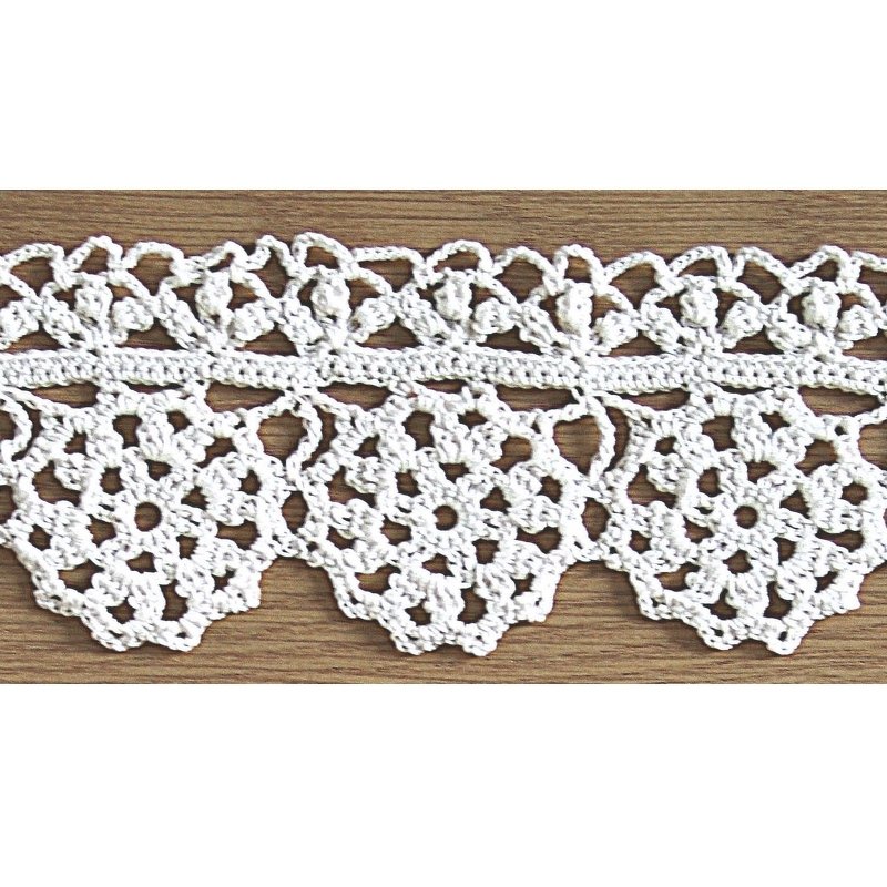 Weiße gehäkelte Spitzenborte mit Blumenmotiven und gezacktem Rand auf Holzuntergrund