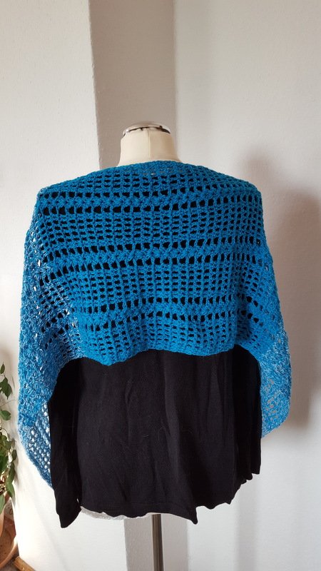 Türkises gehäkeltes Schultertuch mit Lochmuster auf Schaufensterpuppe