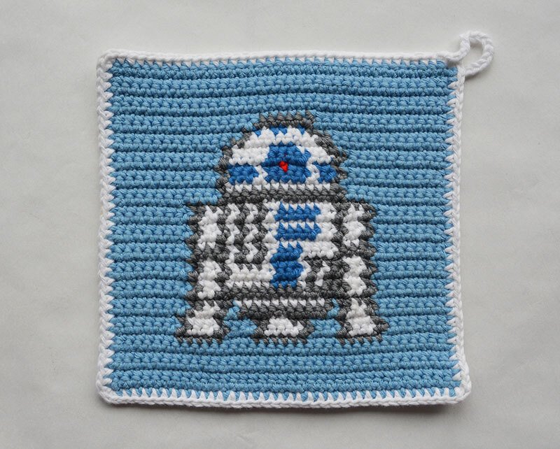 Gehäkelter Topflappen in Pixeloptik mit kleinem Robotermotiv