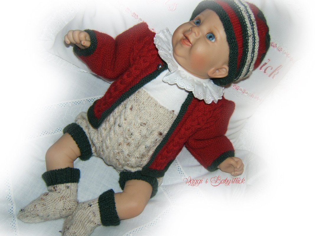 Nahaufnahme einer Babypuppe im farblich abgestimmten gestrickten Strickset mit Jacke, Höschen, Mütze und Socken.