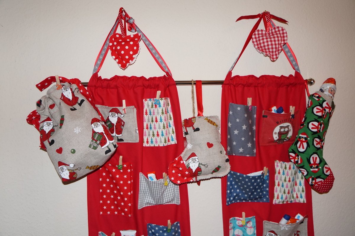 Roter Stoff-Adventskalender mit vielen gemusterten Taschen und dekorativen Herzen