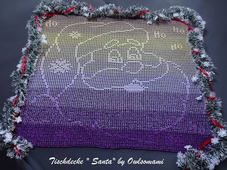 Gehäkelte Filet-Tischdecke mit 'Merry Christmas' und Santa-Motiv, Ombre-Farbverlauf Lila-Gelb, umrandet von einer glitzernden Girlande und roten Bändern