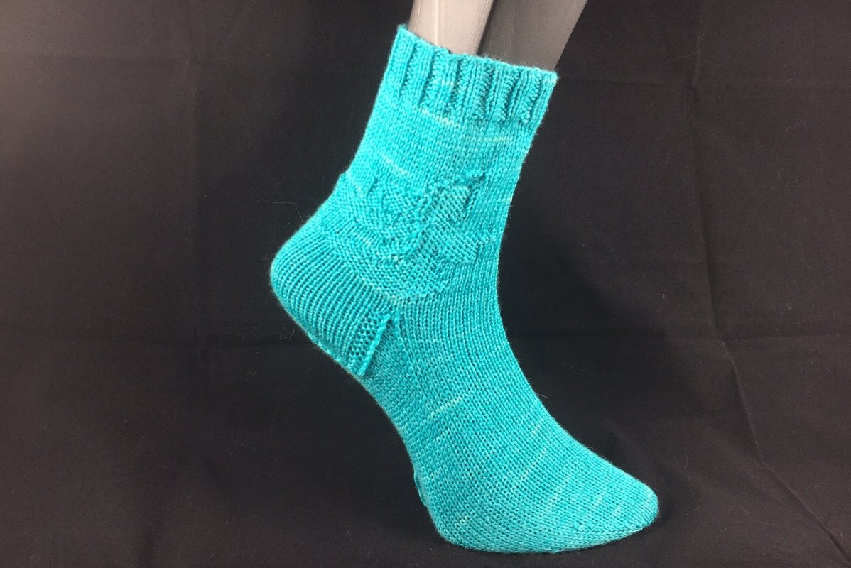 Türkise gestrickte Damensocke am Modellfuß mit Zopfmuster am Schaft