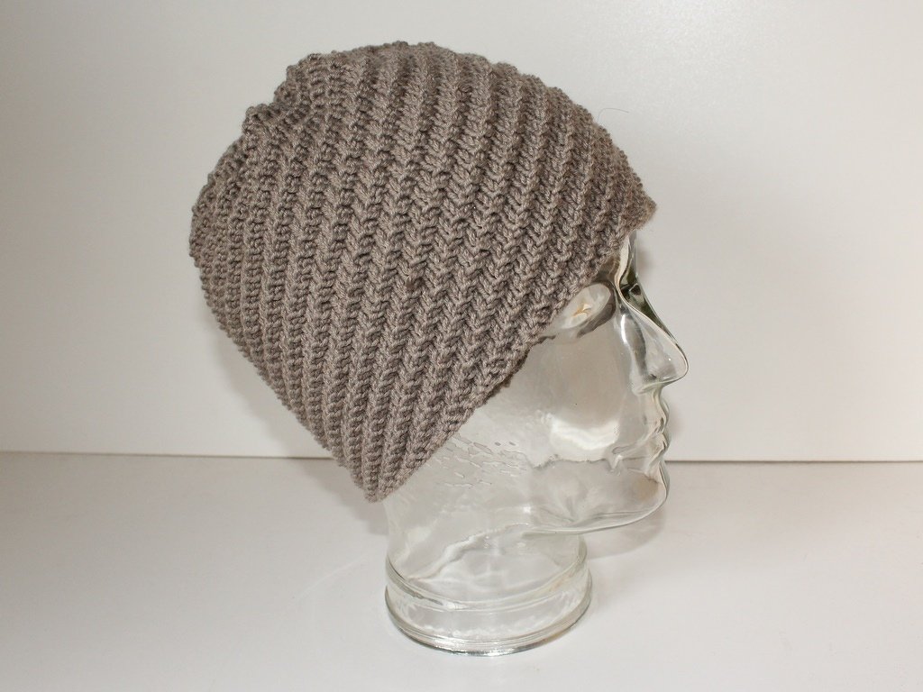 Gestrickte Slouch‑Mütze in Taupe mit schrägem Rippenmuster auf Glaskopf