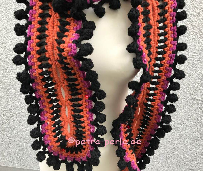 Gehäkelter Schal mit dreifarbiger Noppenbordüre in Orange, Schwarz und Fuchsia und dezenten roten Perlen