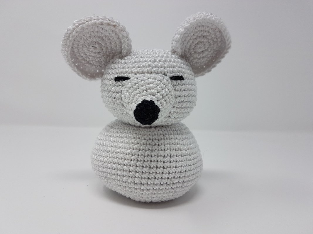 Hellgraue gehäkelte Amigurumi‑Maus mit großen Ohren, geschlossenen Augen und schwarzer Nase auf weißem Hintergrund.
