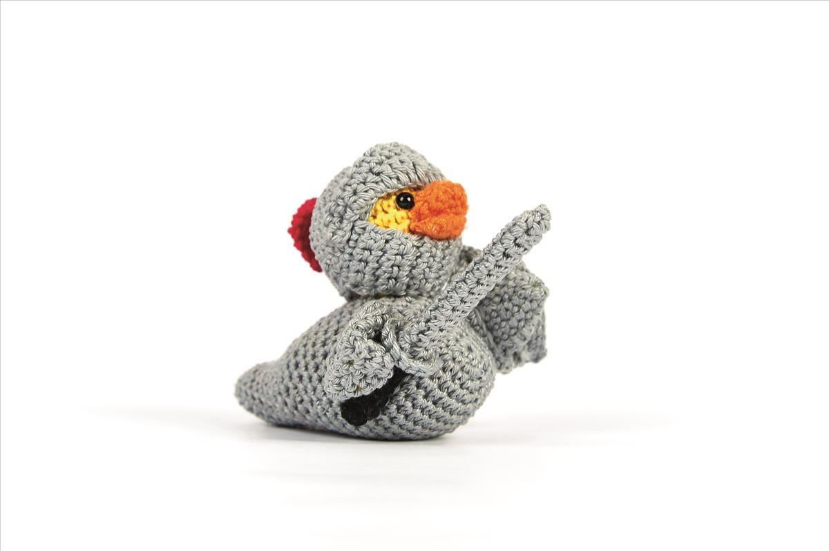 Grau gehäkelte Amigurumi-Ente im Ritterkostüm mit orangefarbenem Schnabel und kleinem Schwert