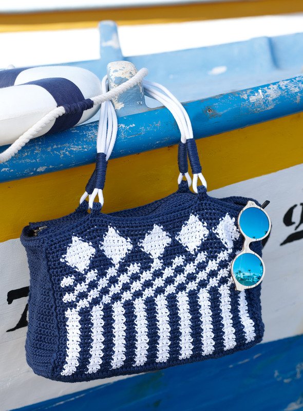 Gehäkelte blau-weiße Henkeltasche mit Rauten- und Streifenmuster und weißen Kordelgriffen