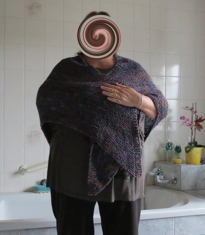 Person trägt dunkles, mehrfarbiges gestricktes Dreieckstuch, locker um die Schultern gelegt