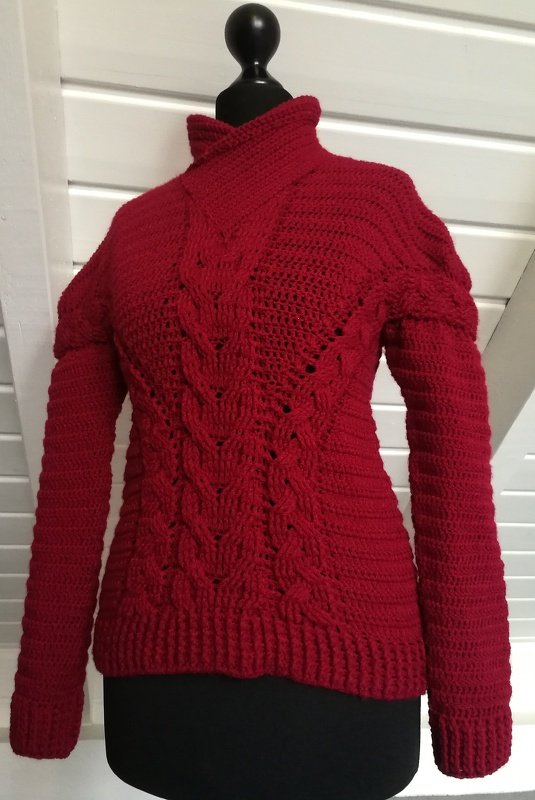 Roter gehäkelter Damenpullover auf Schneiderpuppe mit Zopfmuster und Stehkragen
