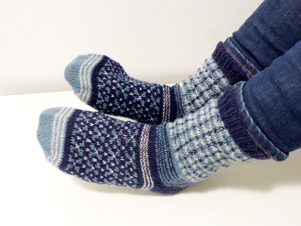 Gestrickte blaue Socken mit Muster, getragen zu Jeans