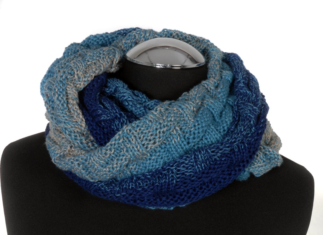 Nahaufnahme eines gestrickten Loop-Schals in Blautönen und Grau mit Textur