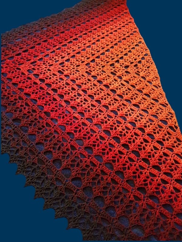 Nahaufnahme eines gehäkelten Lacetuchs mit Blattrapport und Zackenrand in Rot-Orange-Braun