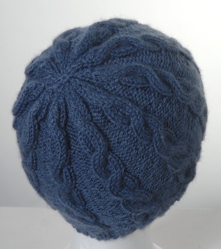 Rückansicht einer gestrickten Zopfmütze in Dunkelblau mit radialem Zopfmuster