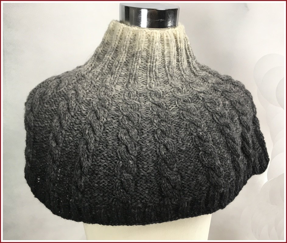 Kurzcape-Loop mit hohem Rippenkragen und vertikalen Zopfreihen, Ombré von Creme zu Anthrazit