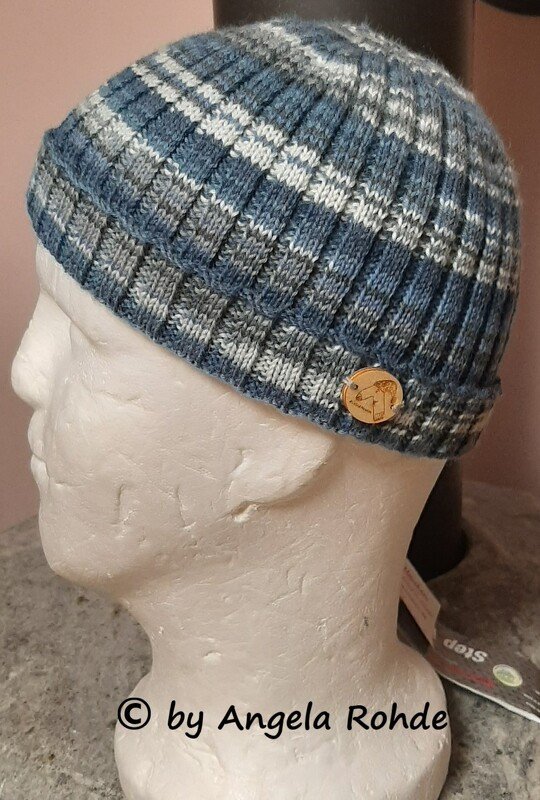 Gerippte Herrenstrickmütze in Blau, Grau und Weiß mit Karomuster auf Schaufensterkopf