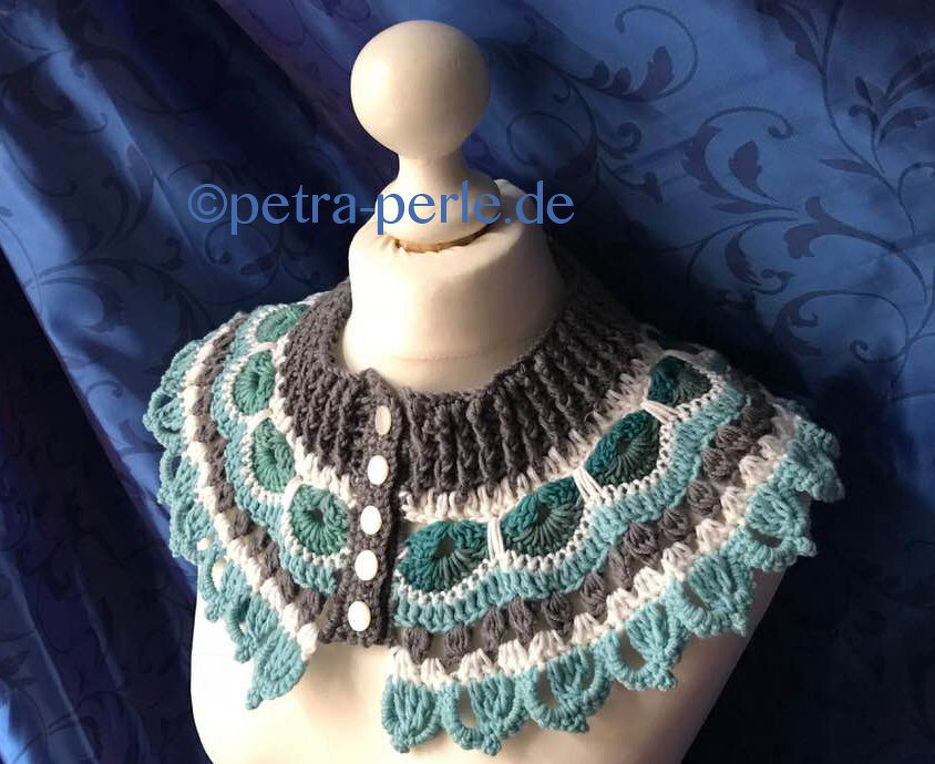 Gehäkelter Kragenschal mit Muschel- und Wellenmuster in Türkis, Grau und Weiß, vorne geknöpft auf einer Schneiderpuppe