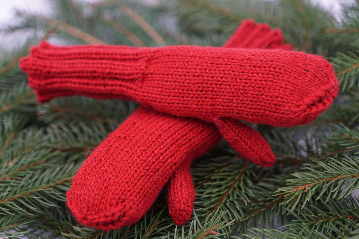 Nahaufnahme roter gestrickter Kinderfäustlinge mit Rippenbündchen