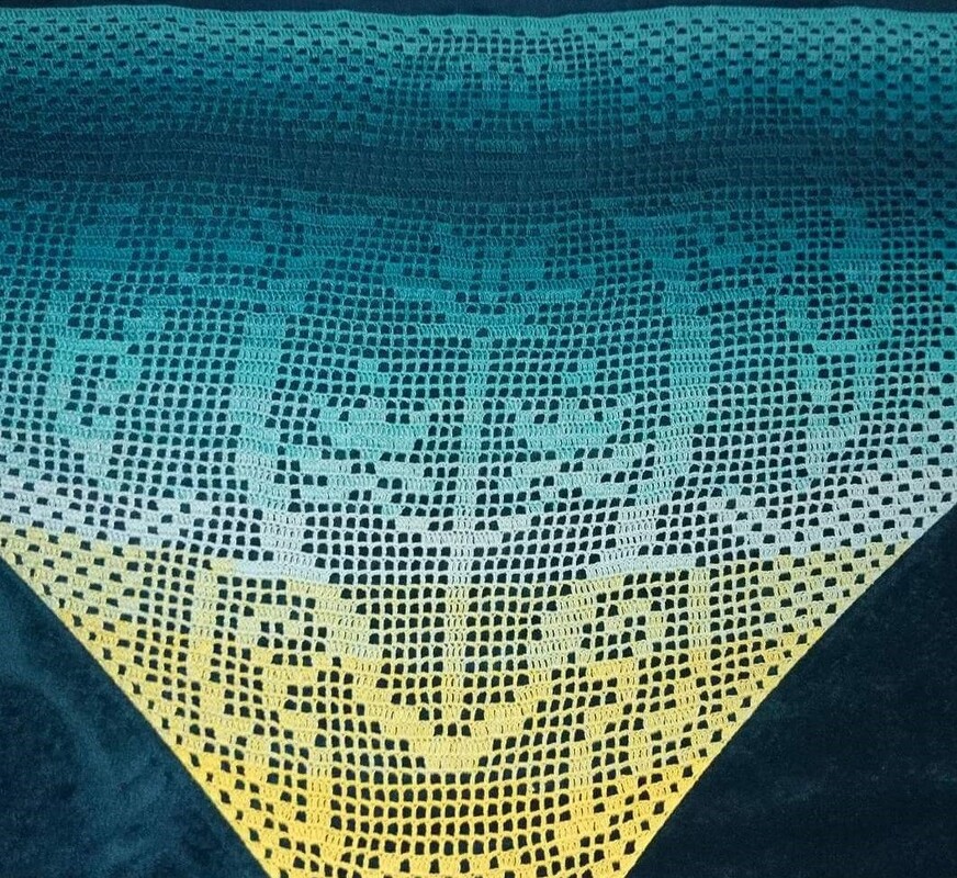 Gehäkeltes Dreieckstuch mit Farbverlauf von Dunkelblau über Türkis zu Gelb und Filethäkelmuster.