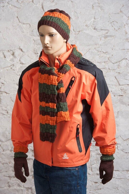 Männliche Schaufensterpuppe trägt orange-grün-braun gestreifte gestrickte Mütze, Schal und Handschuhe mit Korbgeflechtmuster zu einer orangefarbenen Jacke