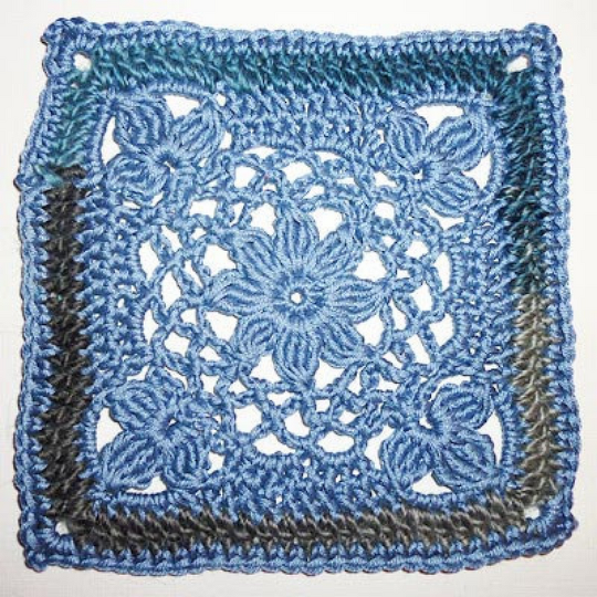Gehäkeltes Granny Square in Blau und Grau mit zentralem Blumenstern und Eckblüten